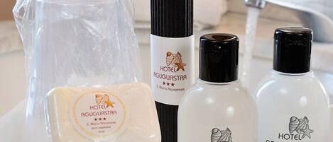 Toiletries including soap, shampoo, and a bottle of lotion, all branded with 'Hotel Aguglia'.