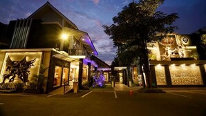 A hotel entrance with a modern design, a large statue, and a well-lit facade. - Griya Persada Convention Hotel & Resort Kaliurang (Pakem)