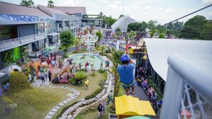 A multi-level outdoor area with a central water feature, surrounded by buildings with balconies and outdoor seating areas. - Griya Persada Convention Hotel & Resort Kaliurang (Pakem)