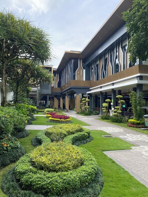 A modern building with a courtyard featuring manicured gardens and a central pathway. - Griya Persada Convention Hotel & Resort Kaliurang (Pakem)