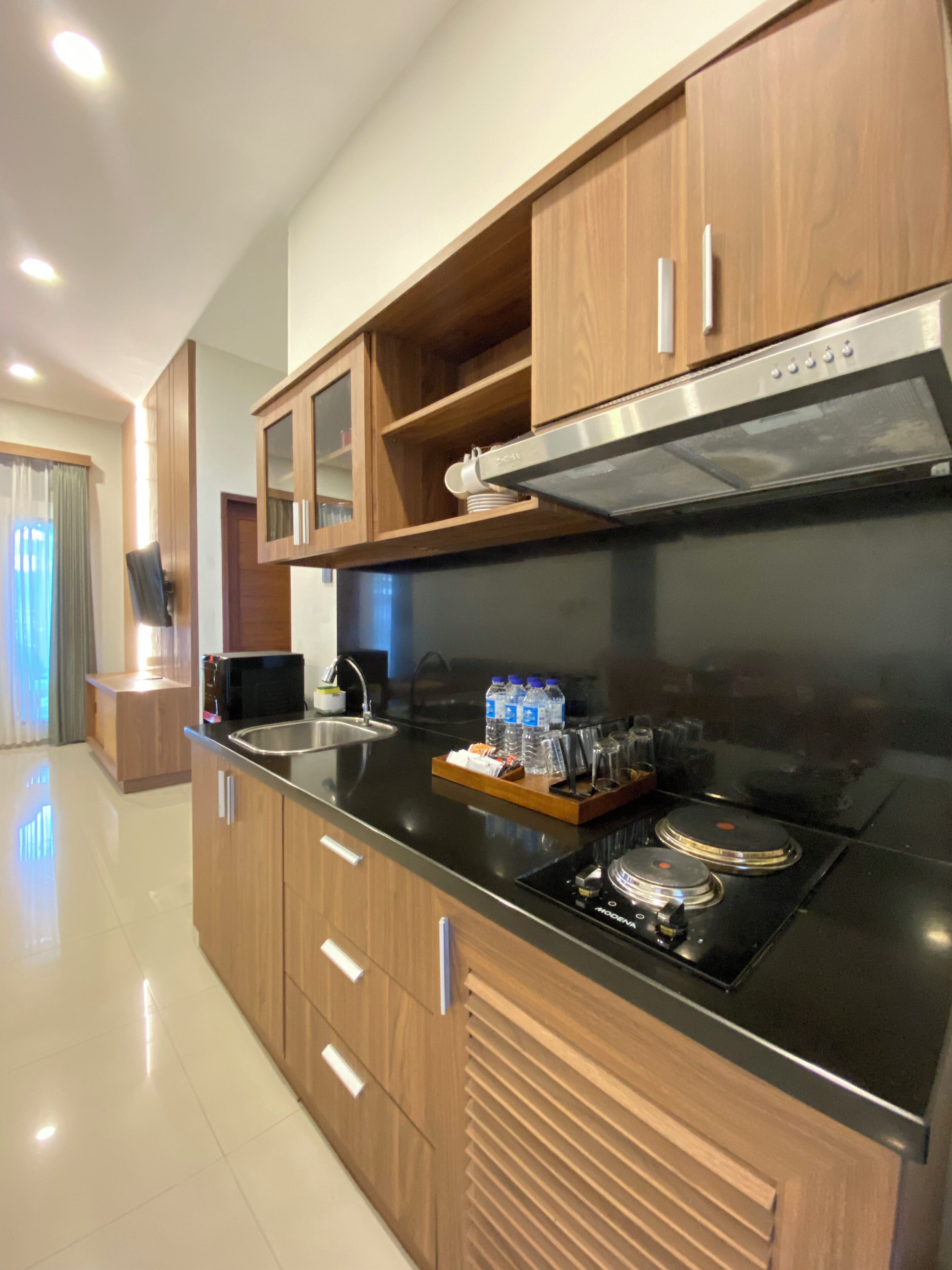 Una cocina moderna con armarios de madera, una campana extractora de acero inoxidable y una estufa integrada.