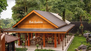 A wooden building named "Bale Kunta" with outdoor seating and a garden. - Griya Persada Convention Hotel & Resort Kaliurang (Pakem)