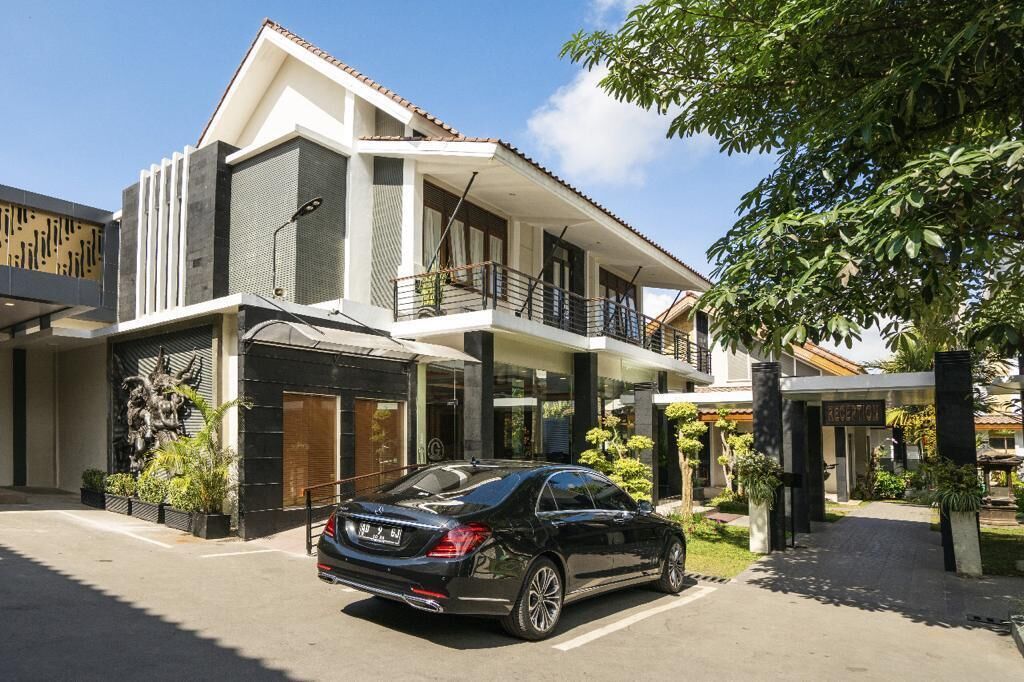 A modern two-story building with a car parked in front.
