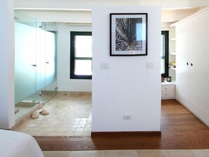 Une pièce moderne et bien éclairée, dotée d’un plancher en bois, d’une cloison en verre et d’une œuvre d’art encadrée au mur.
