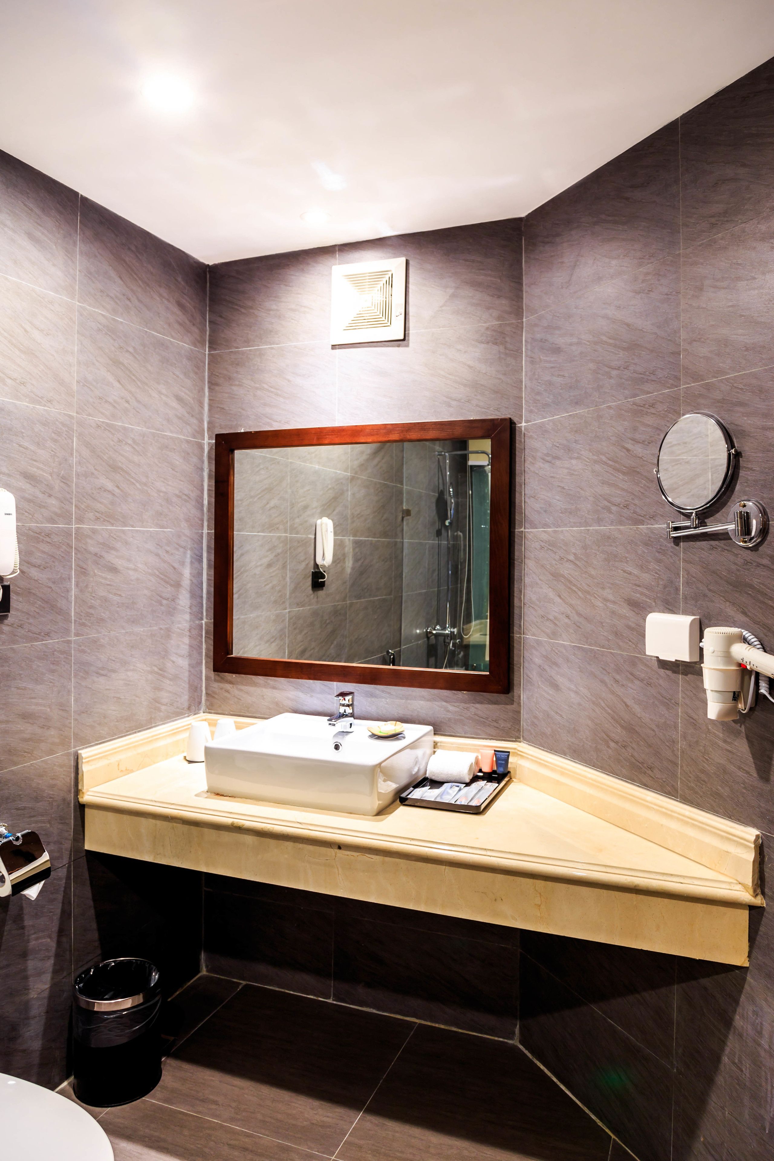 Une salle de bain moderne avec un grand miroir, un lavabo et une douche.