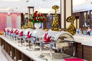 A buffet setup with multiple food service stations, each with a covered serving dish and a spoon. - Muong Thanh Lang Son Hotel (Dong Kinh)