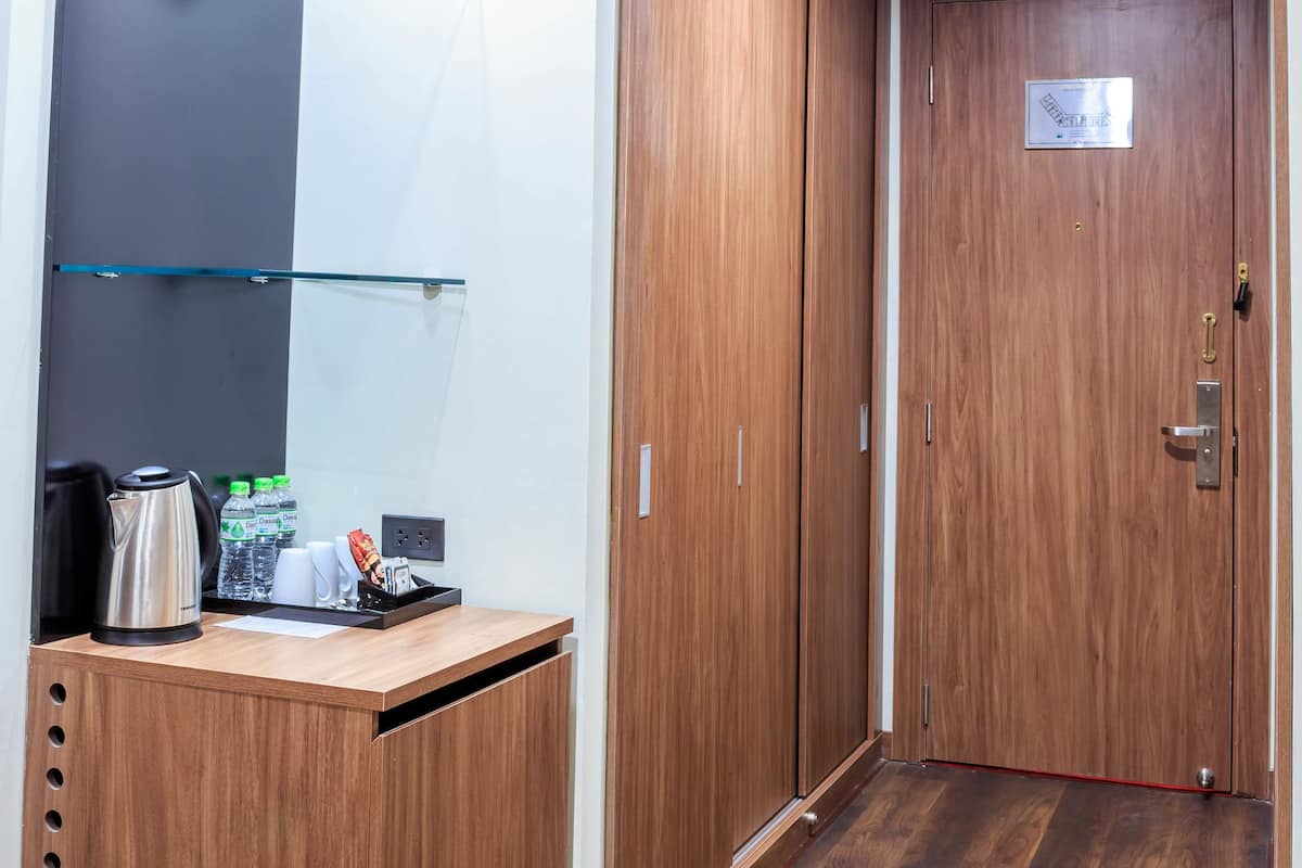 A hotel reception area with a wooden desk, a coffee machine, and a glass shelf.