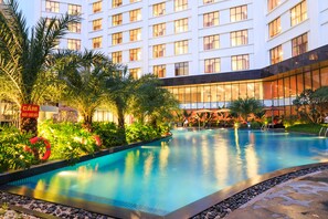 A hotel with a large indoor swimming pool surrounded by lush greenery and palm trees. - Muong Thanh Lang Son Hotel (Dong Kinh)