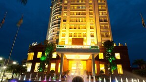 A hotel with a prominent sign reading "MUONG THANH HOTEL" and a large illuminated entrance.