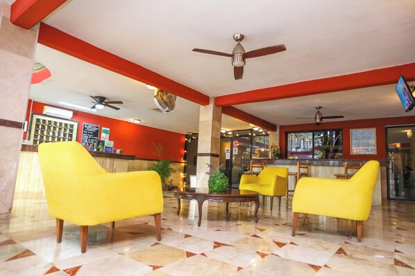 A lobby with yellow chairs, a reception desk, and a bar area. - Hotel Santa Maria Cancun (Cancun)