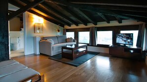 Een moderne woonkamer met een houten plafond, een bank, een salontafel en een televisie.