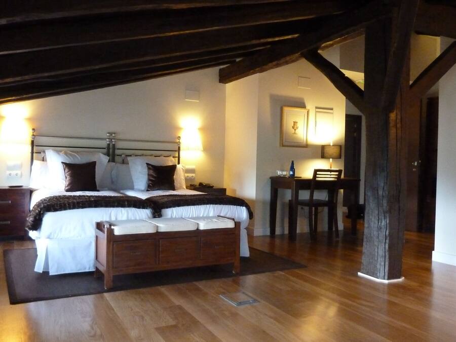 Une chambre à coucher avec un lit en bois, des tables de chevet, un bureau et une chaise.