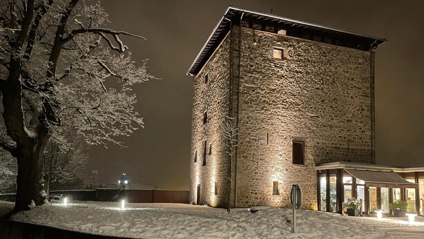 Een gebouw van steen met een plat dak, een klein raam en een deur.