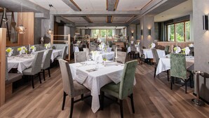 Un restaurante con varias mesas, sillas y suelo de madera.