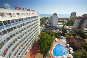 Un hotel con varios pisos, piscina y vista a la playa y al océano.