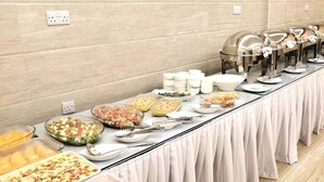 Una taula de buffet amb diferents plats i utensilis.