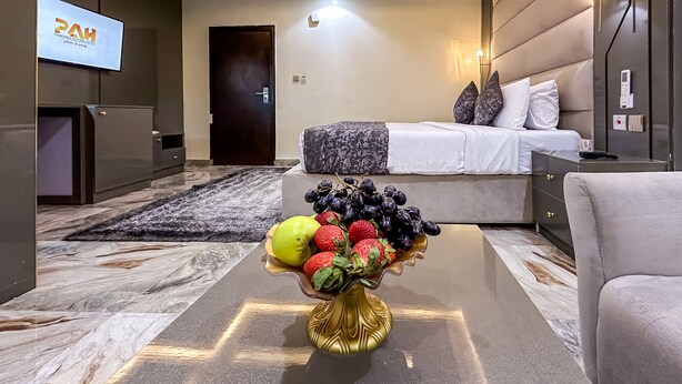 A modern hotel room with a bed, bedside table, and a TV on the wall. - Parkview Astoria Hotel (Lagos)