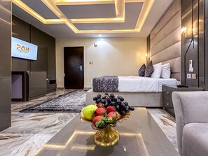 A modern hotel room with a bed, bedside table, and a TV on the wall. - Parkview Astoria Hotel (Lagos)