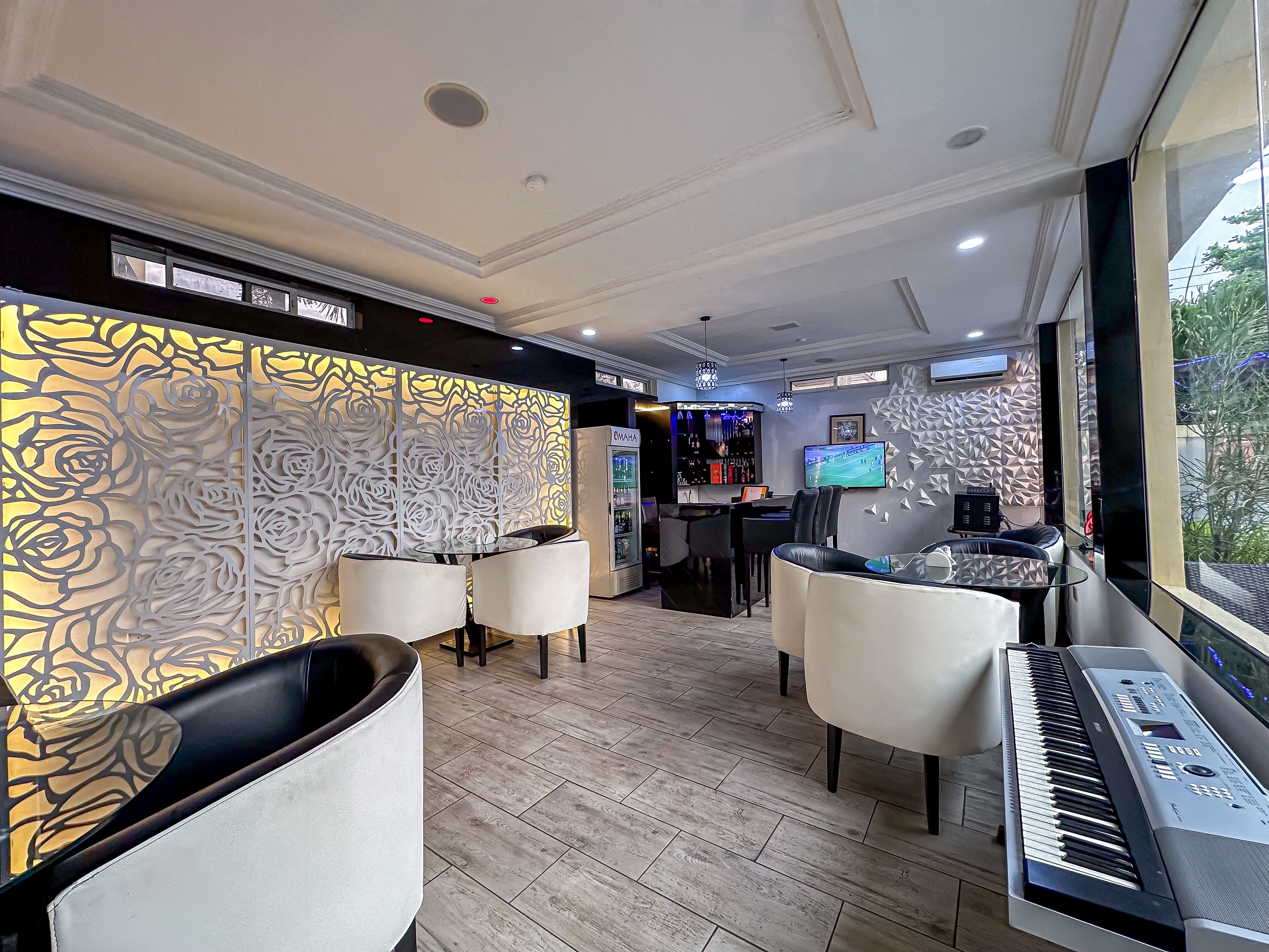 A modern lounge area with a bar, seating, and a piano.