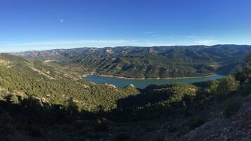 Un paisaje montañoso con un lago rodeado de colinas boscosas.