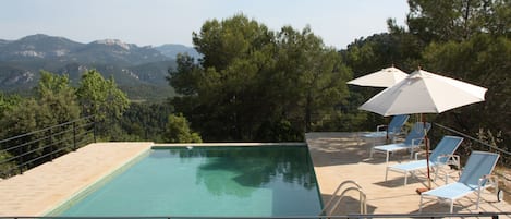 Piscine extérieure, parasols de plage, chaises longues