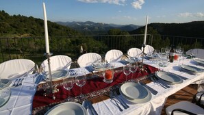 Taula preparada per a dinar, amb una vista panoràmica a les muntanyes de fons.