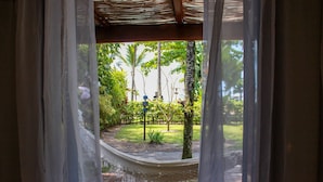 Una hamaca bajo un pérgola de madera con vistas a un jardín.