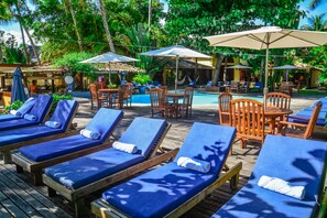 Una piscina al aire libre, sillones reclinables de piscina