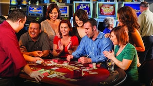 A group of people playing blackjack at a casino table with chips and cards. - Pahrump Nugget Hotel and Casino (Pahrump)