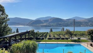 Una piscina con vistas a un lago y montañas.