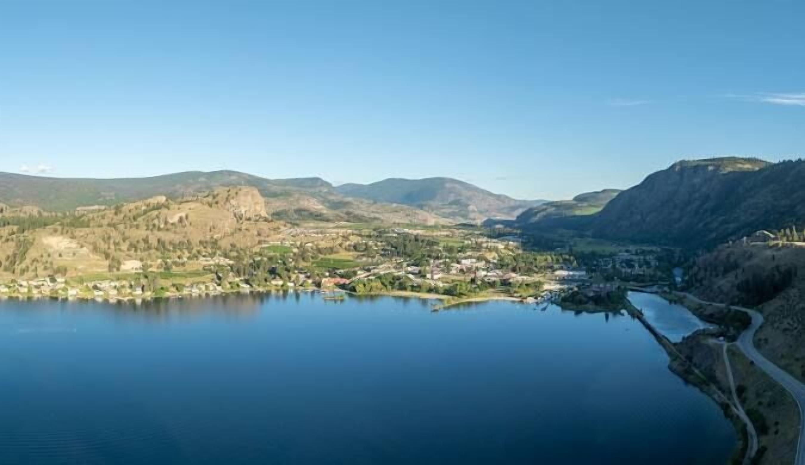 A lake surrounded by hills with a small town in the foreground.