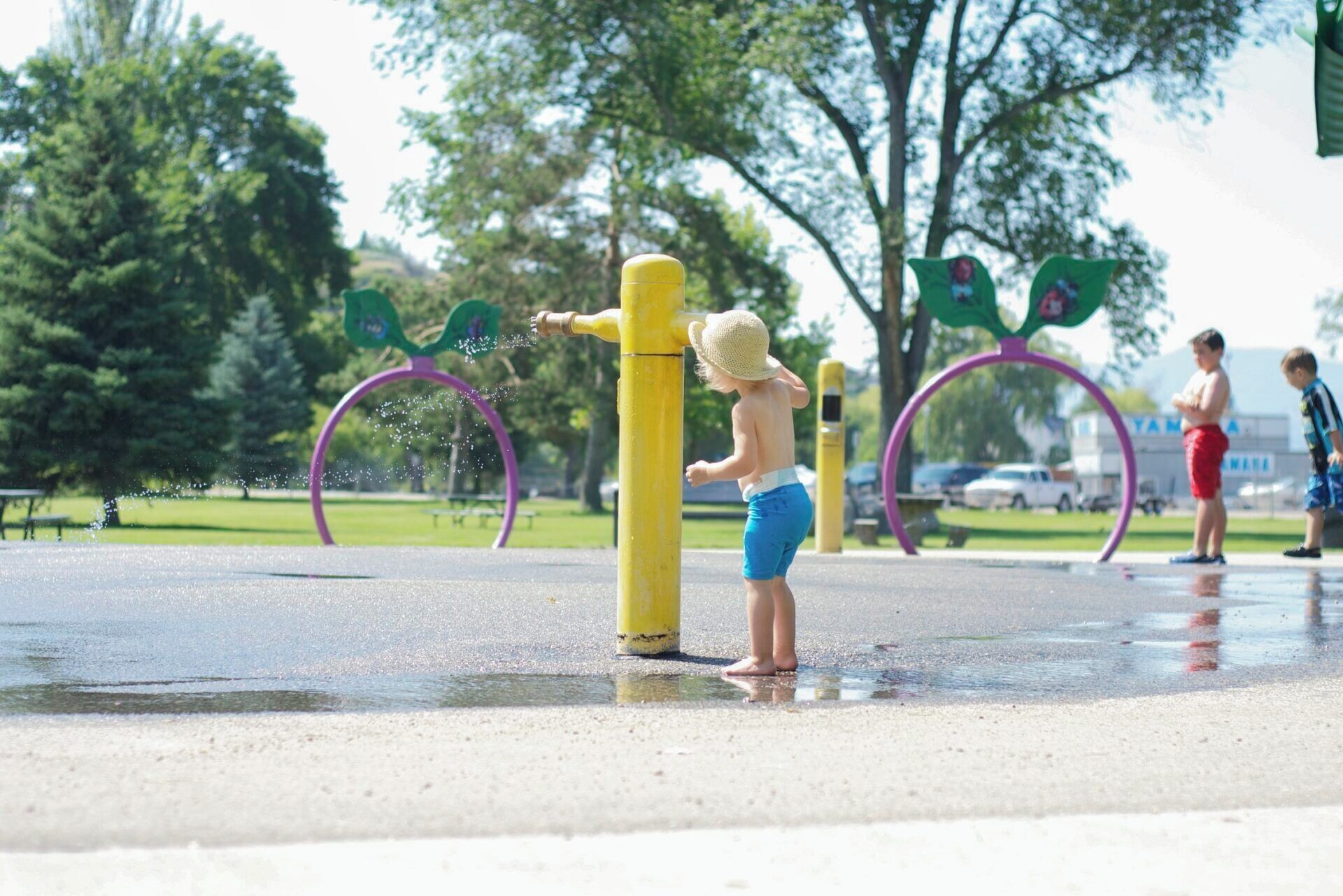 Niño jugando con una fuente de agua en un parque.