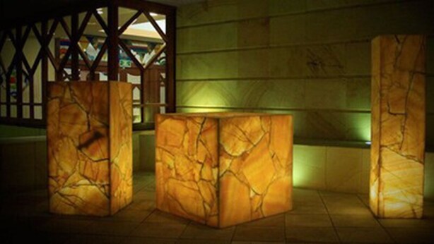 A room with three marble-like columns, a wooden lattice structure, and a green-lit wall. - Hotel Max (Mexico City)