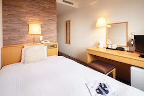 A hotel room with a bed, a desk with a computer, a telephone, and a mirror. - Central Hotel Imari (Imari)