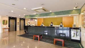 A hotel reception area with a reception desk, three staff members, and a clean, modern interior. - Central Hotel Imari (Imari)