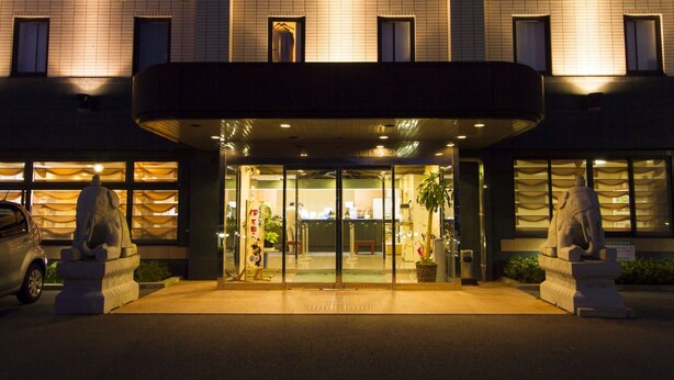 A hotel entrance with a covered entrance, glass doors, and two elephant statues. - Central Hotel Imari (Imari)