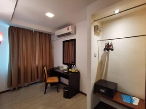 Une chambre d’hôtel équipée d’un bureau, d’une chaise et d’un porte-manteau.
