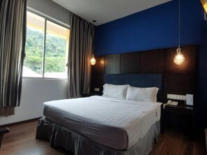 A bedroom with a large bed, a window with curtains, a bedside table with a lamp, and a wall-mounted phone. - 2 Inn 1 Boutique Hotel & Spa (Sandakan)