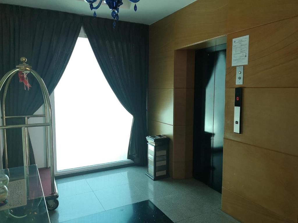 A hotel lobby with a large window, an elevator, and a reception desk.