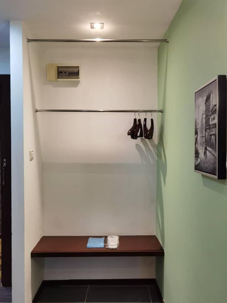 A room with a coat rack, a bench, and a framed picture on the wall.