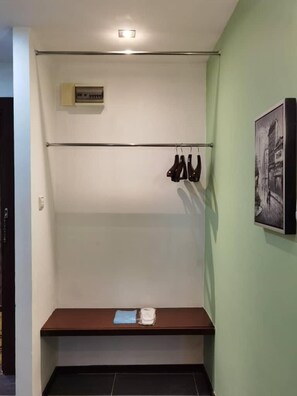 A room with a coat rack, a bench, and a framed picture on the wall. - 2 Inn 1 Boutique Hotel & Spa (Sandakan)