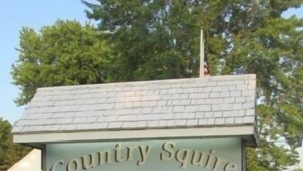 A motel sign with amenities including WiFi, fridge, and microwave. - Country Squire Motel (Littleton)