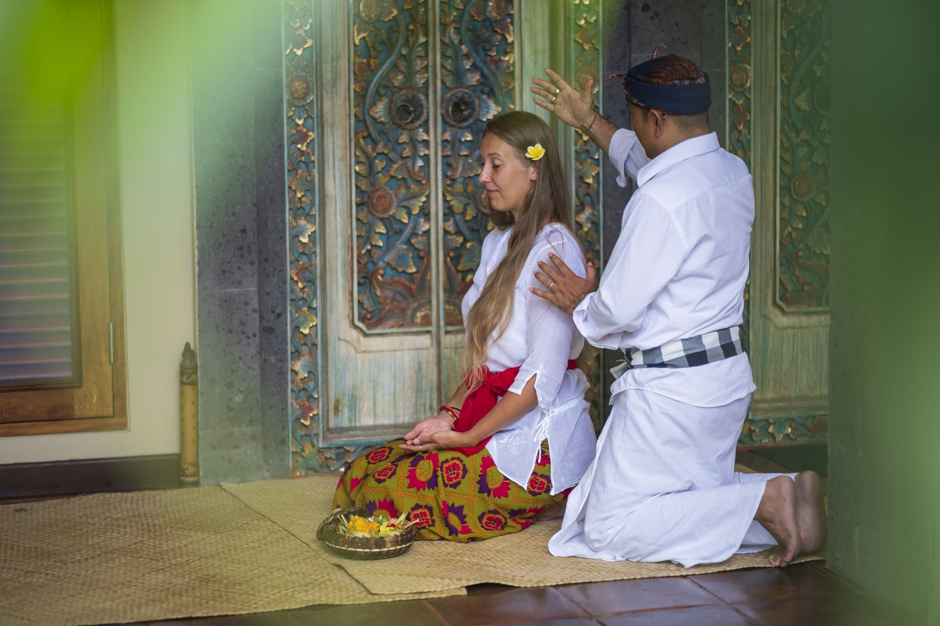 A traditional ceremony with a woman in a colorful dress and a man in white attire.