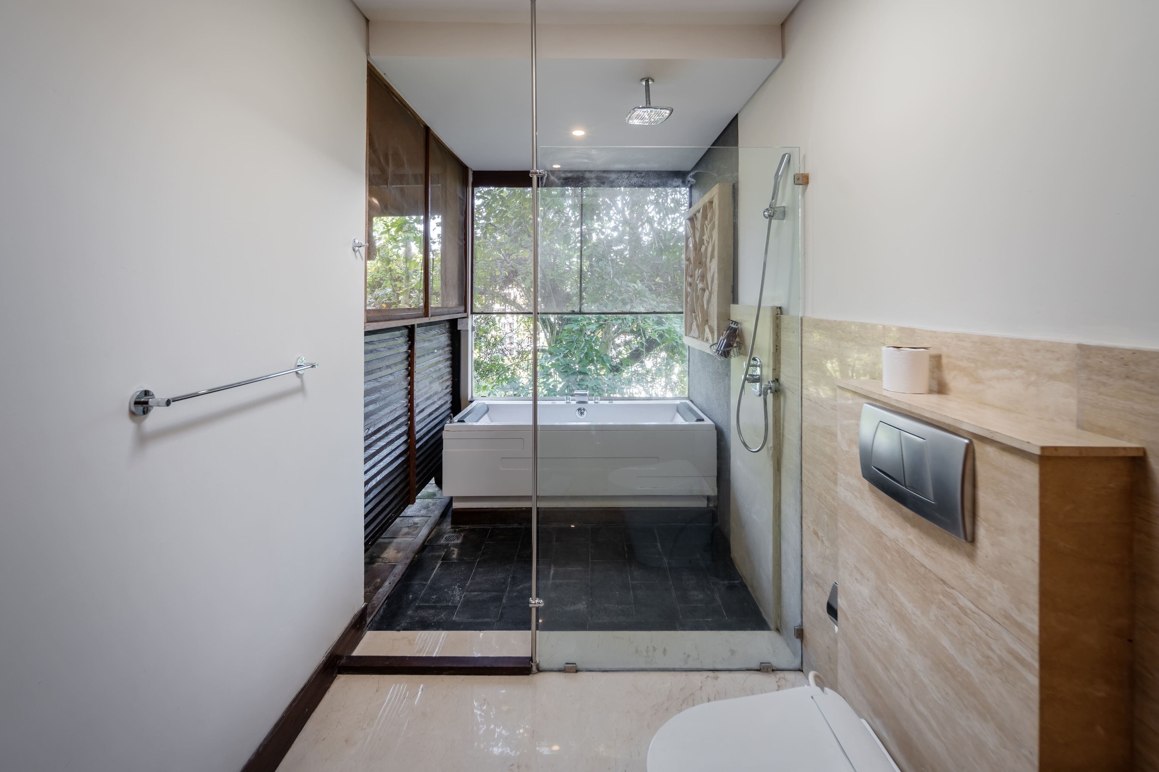 Un baño moderno con ducha de vidrio, bañera independiente y un inodoro.