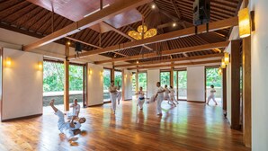 A spacious room with wooden floors and large windows, allowing natural light to enter. - Adiwana Svarga Loka (Ubud)