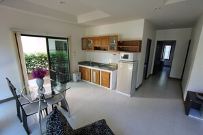 Departamento familiar, 2 habitaciones, acceso a la alberca, vista a la alberca | Área de sala de estar | Televisión LCD de 32 pulgadas con canales por cable y televisión