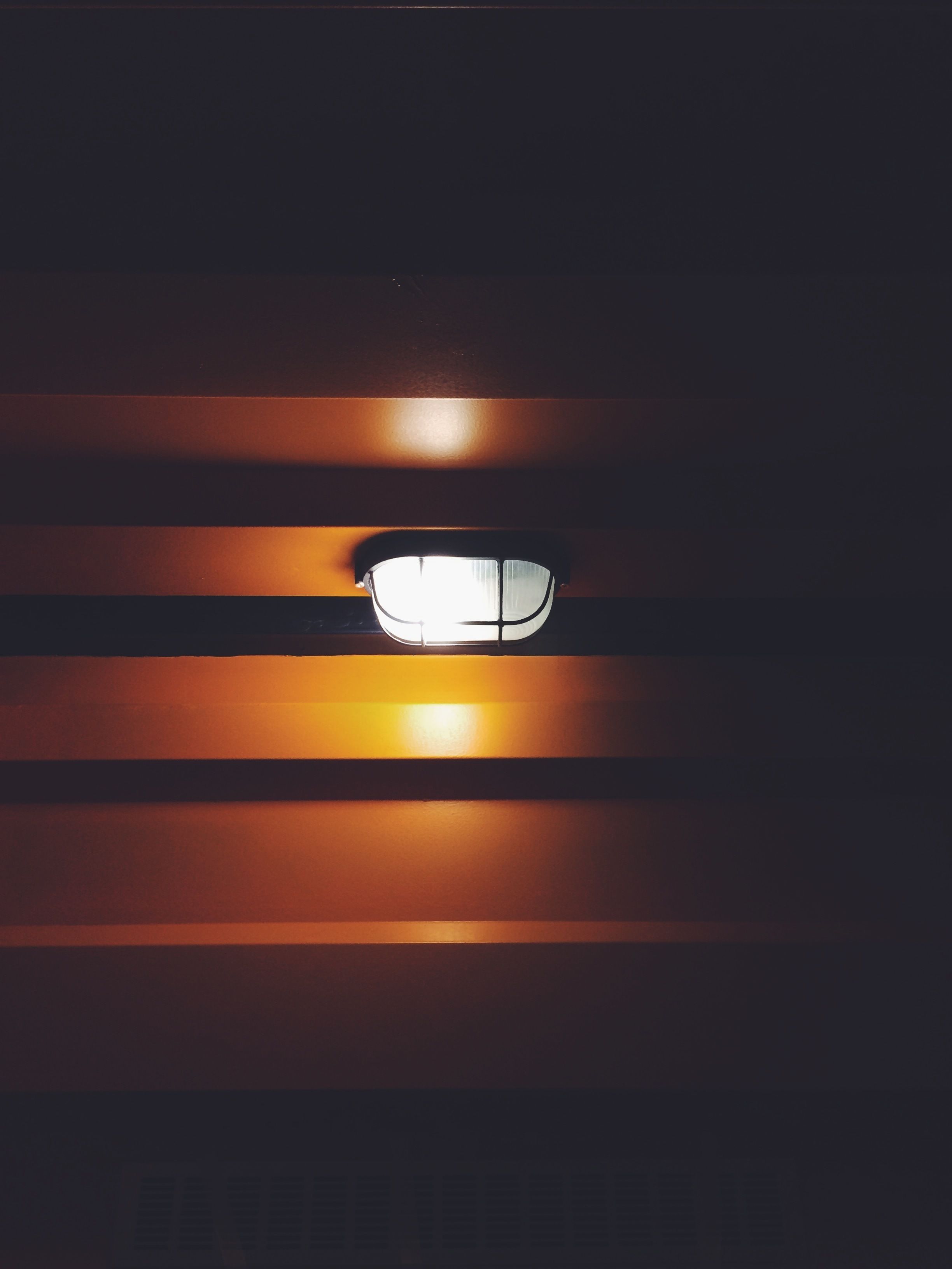 A close-up of a wall with horizontal stripes and a light fixture.