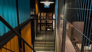 Una escalera con barandillas metálicas y una pared azul a un lado.