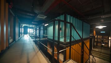 A corridor with bunk beds, a staircase, and a view into another room.