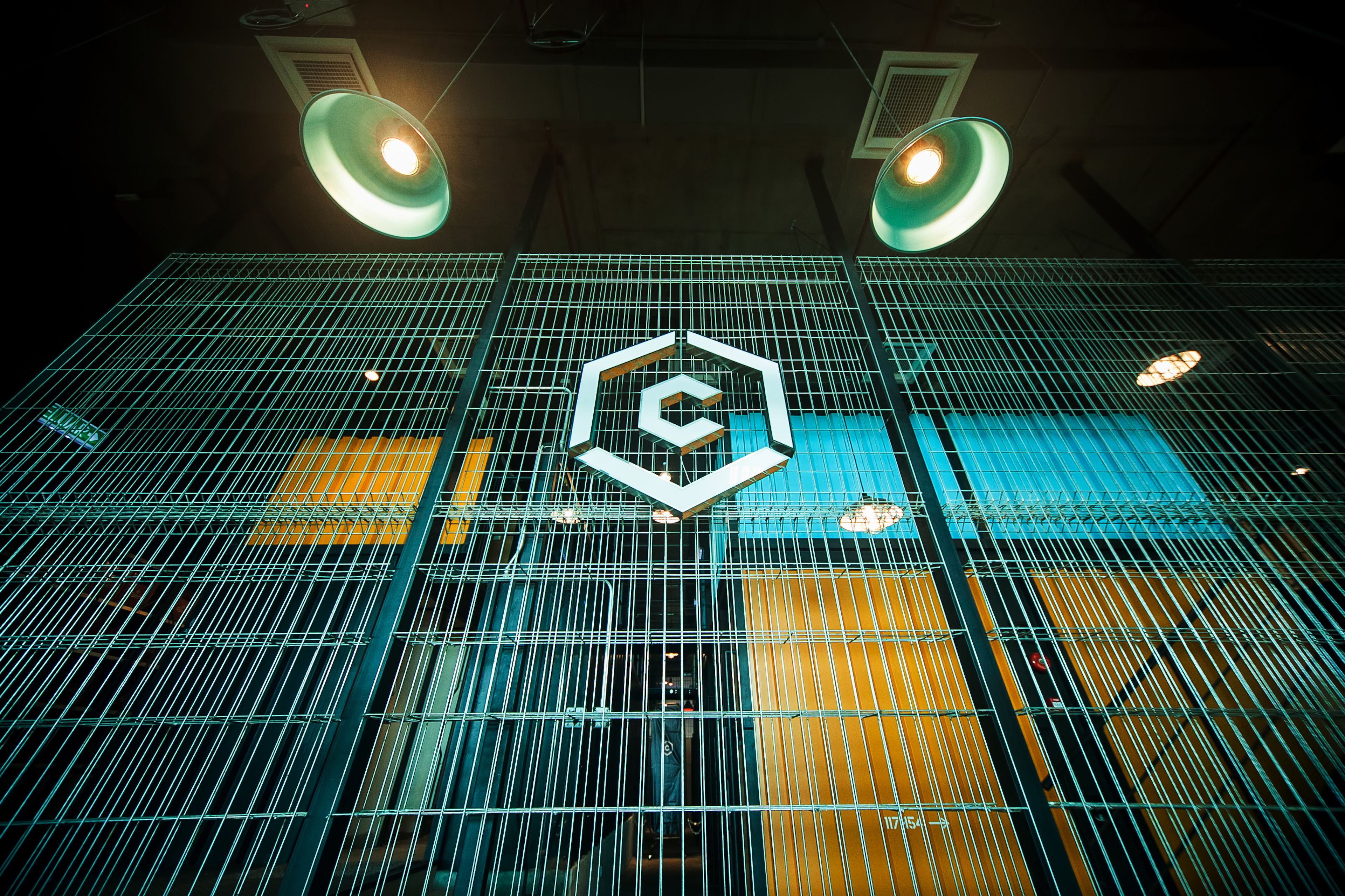 Un edificio moderno con fachada de vidrio geométrica y un logotipo hexagonal destacado.